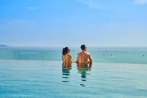 a man and a woman standing in the water at Sheraton Nha Trang Hotel & Spa in Nha Trang