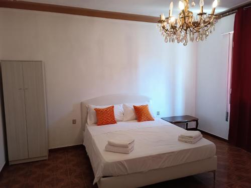 a bedroom with a bed with orange pillows and a chandelier at Locazione Turistica in Tessera