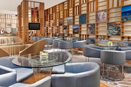 a restaurant with tables and chairs and a tv at Sheraton Nha Trang Hotel & Spa in Nha Trang