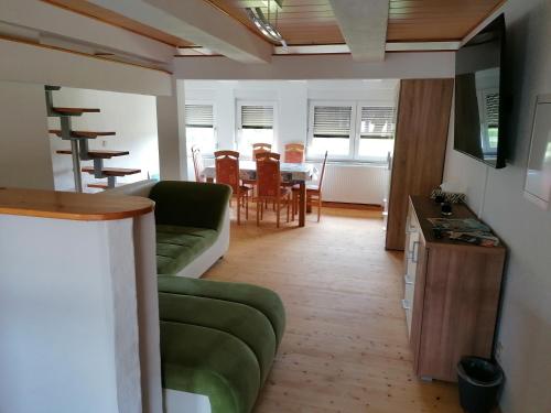 ein Wohnzimmer mit einem grünen Sofa und einem Tisch in der Unterkunft Ferienwohnung Max in Schirgiswalde
