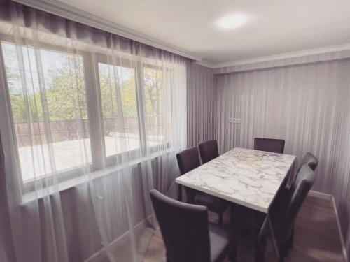 a dining room with a table and chairs and a window at Gardenia in Tsqaltubo