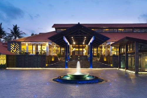 a building with a fountain in front of a building at Sheraton Lampung Hotel in Bandar Lampung