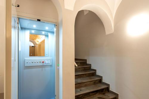 a hallway with a staircase with a blue door and a mirror at La casa di Oliva in Macerata