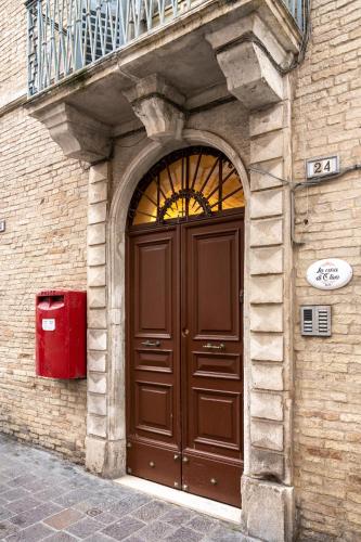 a large brown door on a building with a balcony at La casa di Oliva in Macerata