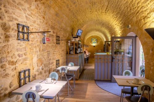 un restaurant avec des tables et des chaises dans un tunnel dans l'établissement Hôtel des Récollets, à Sarlat-la-Canéda