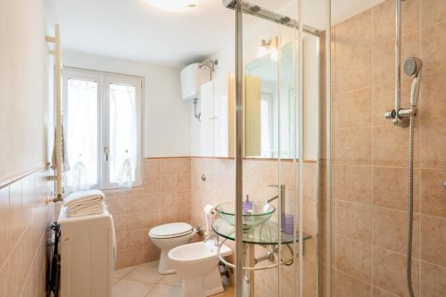 a bathroom with a toilet and a glass shower at La casa di Oliva in Macerata