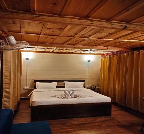 a bedroom with a bed with a ribbon on it at Shivalik Resorts in Barkot