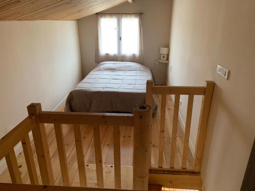 Un pequeño dormitorio con una cama y una escalera en Le Dugas, en Saint-Denis