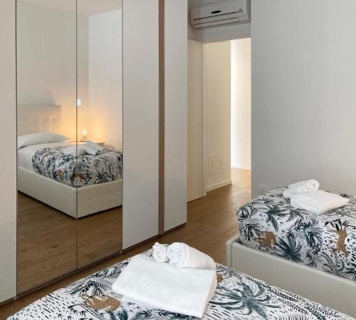 1 dormitorio con 2 camas y espejo en Lecco delight - A perfect gateaway at Como lake en Lecco