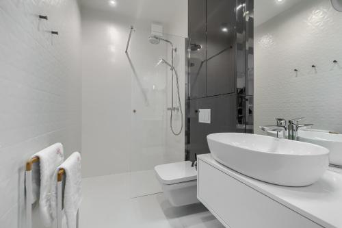 a white bathroom with a sink and a toilet at Your Holidays Waves B431 in Międzyzdroje
