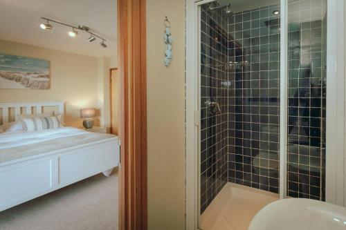 a bathroom with a shower and a bed and a tub at Harbour Views at Silver Strand in Pevensey