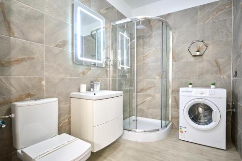 La salle de bains est pourvue de toilettes et d'un lave-linge. dans l'établissement SeaVibes B10 - Pool & Spa Beach Resort, à Mamaia Nord – Năvodari