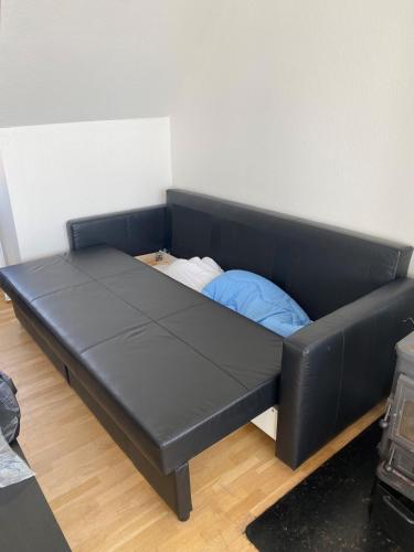 a black futon bed in a room at Udsigt Østersøen in Rønne