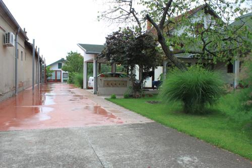 einen nassen Bürgersteig in einem Wohnviertel mit einem Haus in der Unterkunft Boulevard Garden House - Free and save parking in the yard in Ćuprija