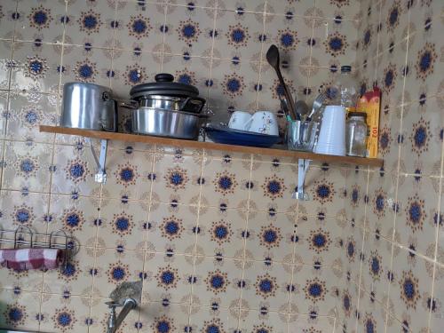 una cocina con una estantería con ollas y sartenes en la pared en Casa inteira e quartos individuais!, en Belo Horizonte