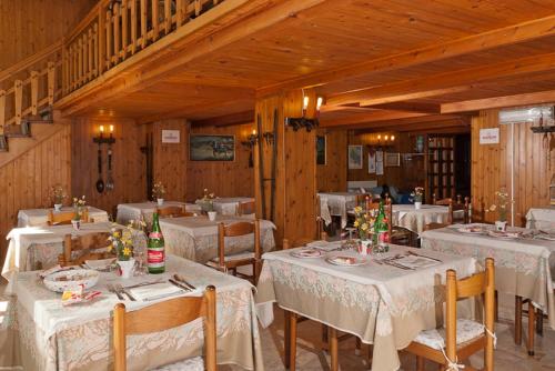 una sala da pranzo con tavoli bianchi e pareti in legno di Hotel Del Postiglione a Ischia