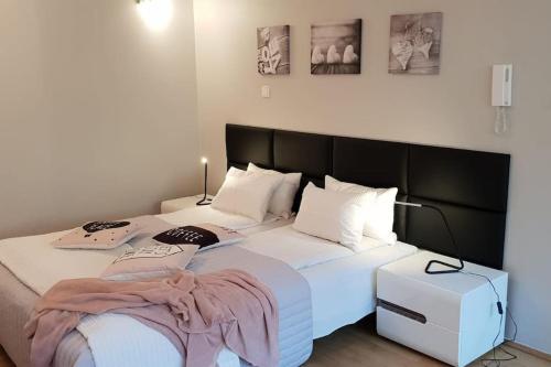 - une chambre avec un grand lit blanc et une tête de lit noire dans l'établissement GOLDEN APARTMENTS with Lift - OLD TOWN, à Cracovie