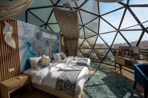 a bedroom with a bed in a room with a window at Petra Seasons luxury Resort in Al Ḩayy