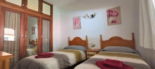 a bedroom with two beds with red towels on them at Casa Pepito in Agulo