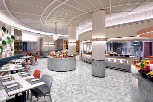 a restaurant with tables and chairs and a buffet at Sheraton Surabaya Hotel & Towers in Surabaya