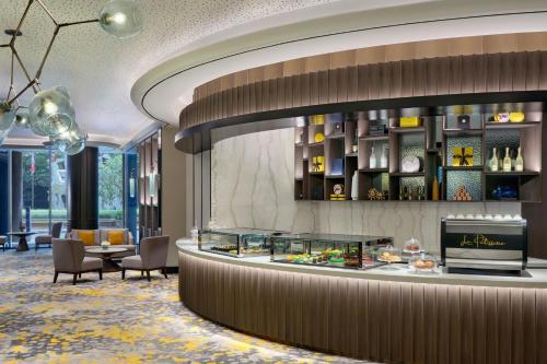 a lobby of a hotel with a food counter at Sheraton Surabaya Hotel & Towers in Surabaya
