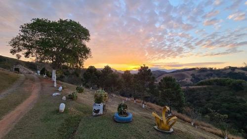 a view of a field with a sunset in the background at Canto do Vento Hospedaria in Santo Antônio do Pinhal