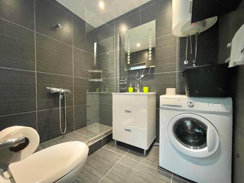 a bathroom with a washing machine and a toilet at Sea view Apartments Panorama Przno in Sveti Stefan