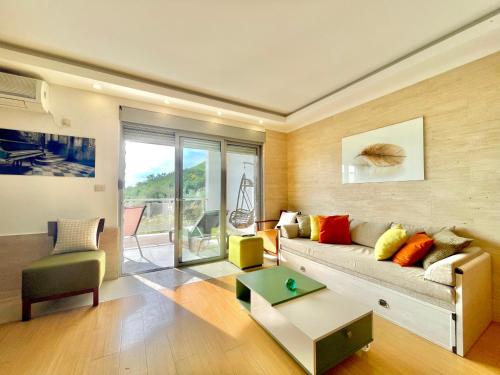 a living room with a couch and a table at Sea view Apartments Panorama Przno in Sveti Stefan