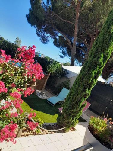 un giardino con fiori rosa e una sedia blu di chambre Zen a Marseillan