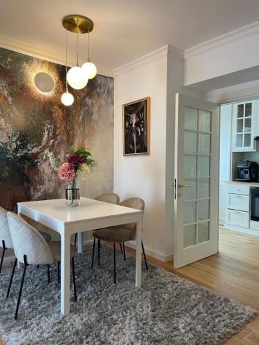 una sala da pranzo con tavolo e sedie bianchi di Premium Central Apartment a Braşov