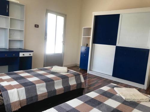 a room with two beds and a desk and a window at Safi Kitchen Hostel in Aş Şāfī