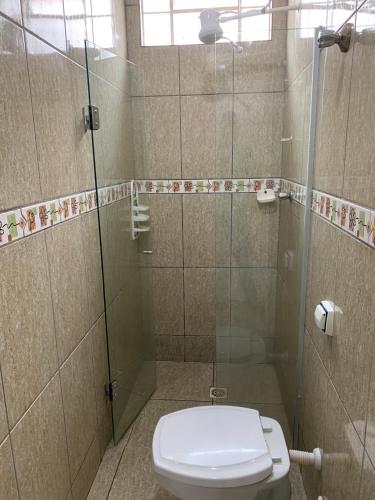 a bathroom with a toilet and a glass shower at Pissin Plaza Hotel in Goiânia