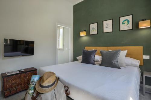 a bedroom with a large white bed with a hat on it at I Levrieri in Torre del Lago Puccini