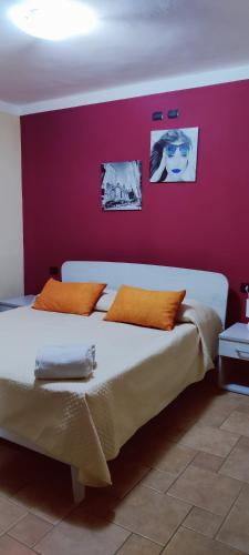 um quarto com uma cama grande e uma parede vermelha em Casa Agnese em Marina di Camerota