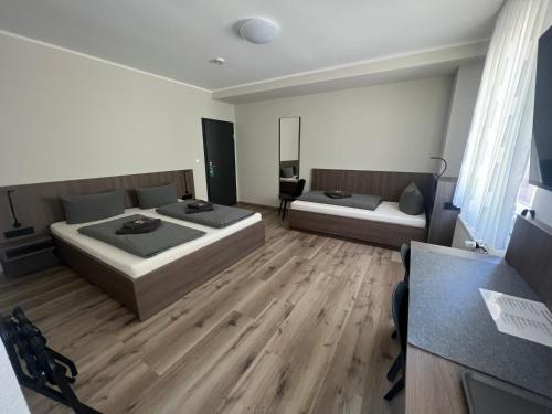 two beds in a room with wooden floors at Hotel Stockumer Hof in Werne an der Lippe