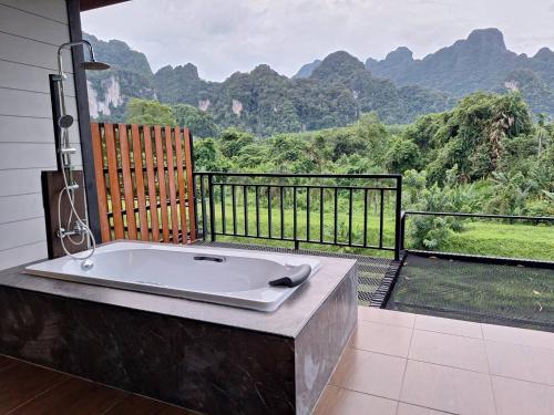 a bath tub with a view of a mountain at Phu Siab Mhok@KhaoSok in Khao Sok