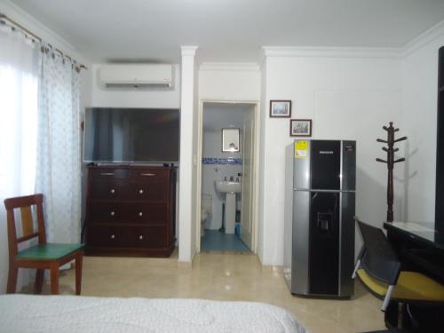 a living room with a refrigerator and a bedroom at Habitación privada in Neiva
