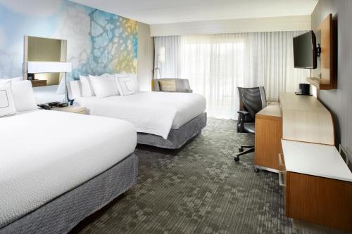 a hotel room with two beds and a television at Courtyard by Marriott State College in State College