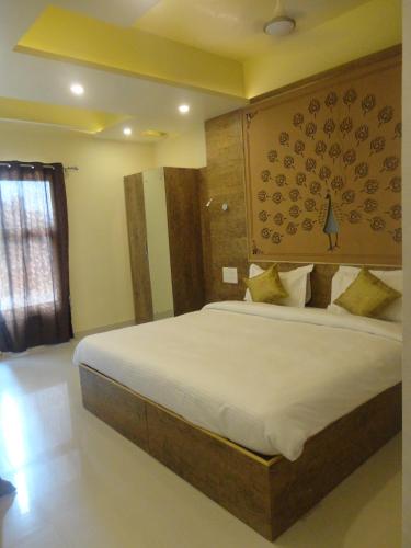a bedroom with a large bed with a wooden headboard at Hotel Banaras Haveli in Varanasi
