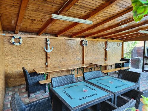 un patio con mesas y sillas y techo de madera. en Vila Olimpica, en Costinesti