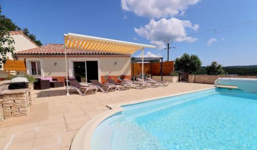 une piscine avec des chaises et une maison dans l'établissement Gîte myosotis Piscine Privée 4 Chambres, à Lagorce