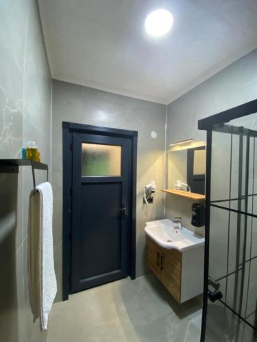 a bathroom with a black door and a sink at NİKA in Çamlıhemşin