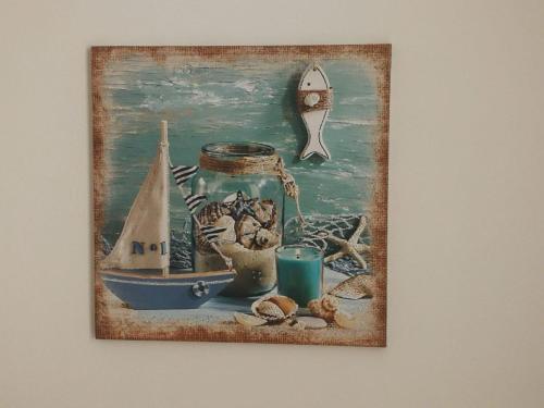 a picture of a painting of a boat and a jar at La casetta di Ramona in Noto