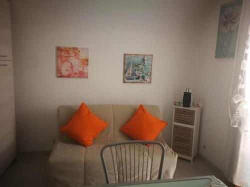 a living room with a couch with two orange pillows at La casetta di Ramona in Noto