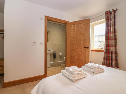 a bedroom with a bed with towels on top of it at Dubh Sgeir Annex in Berwick-Upon-Tweed