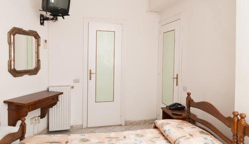 a bedroom with a bed and a mirror at Hotel Del Postiglione in Ischia