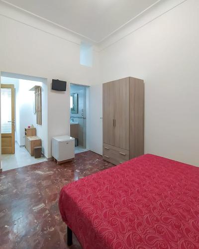a bedroom with a red bed and a wooden cabinet at Nopal casa vacanze in San Vito dei Normanni
