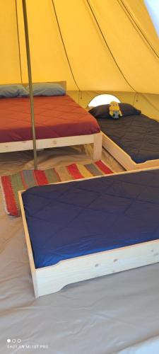 2 camas en una tienda de campaña con sus cubiertas en Tienda de lujo 5 personas - Camping Playa de Tapia, en Tapia de Casariego