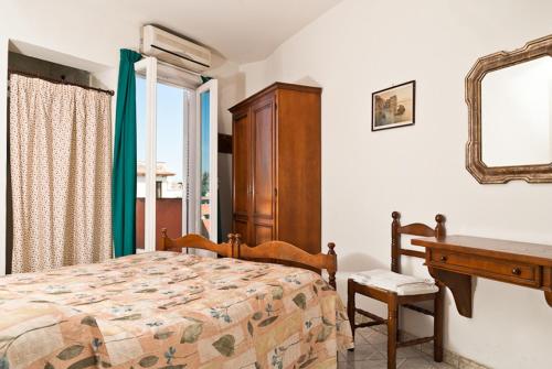a bedroom with a bed and a desk and a mirror at Hotel Del Postiglione in Ischia