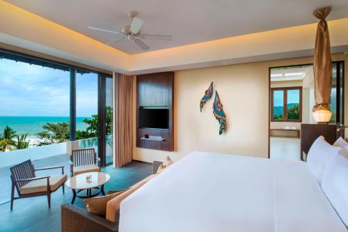 a bedroom with a large bed and a view of the ocean at Vana Belle, A Luxury Collection Resort, Koh Samui in Chaweng Noi Beach